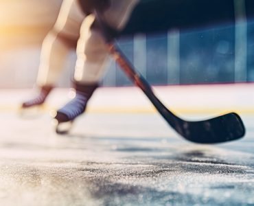 close-up of hockey skates and hockey stick on rink